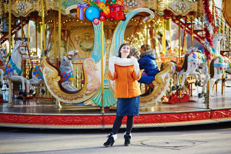 Cheerful young girl on a Christmas market in Parisの写真素材