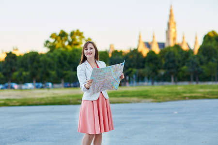 Beautiful young woman walking in Vienna, Austria and using map