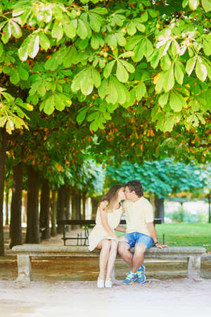 Beautiful young dating couple in Paris in the Tuileries garden on a warm and sunny autumn dayの写真素材