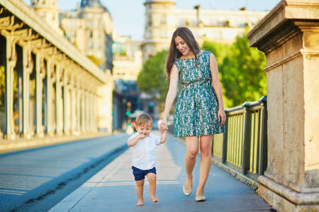 Beautiful young mother with her adorable little son on the Bir Hakeim bridge in Paris, Franceの写真素材