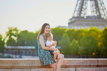 Beautiful young mother with her adorable little son on the Bir Hakeim bridge in Paris, Franceの写真素材