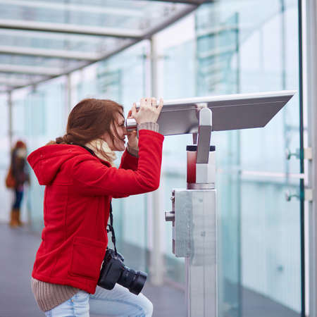 Cheerful young tourist using telescope on the Montparnasse tower observation deck in Parisの写真素材
