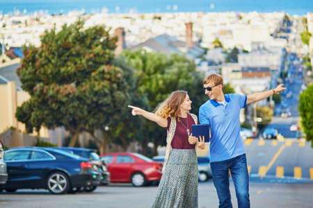 Romantic couple of tourists using tablet and planning their itinerary in San Francisco, California, USAの写真素材
