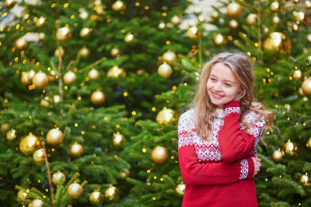 Girl with a brightly decorated Christmas tree in Parisの写真素材