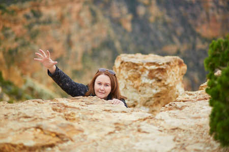 Tourist in Grand Canyon National Park, USA, posing for funny picture, pretending to fallの写真素材