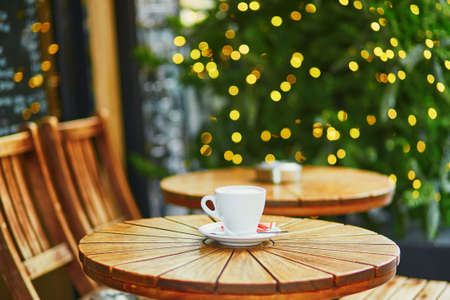 Delicious coffee or hot chocolate in Parisian street cafe decorated for Christmasの写真素材