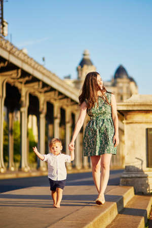 Beautiful young mother with her adorable little son on the Bir Hakeim bridge in Paris, Franceの写真素材