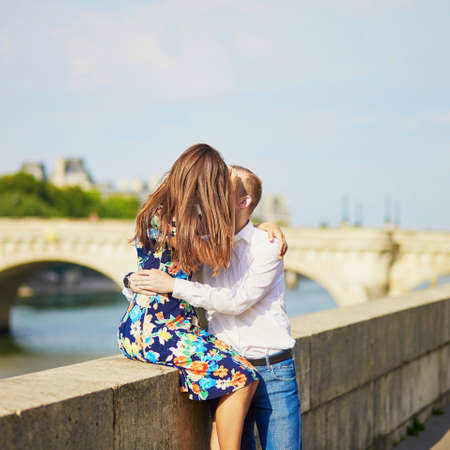 Young romantic couple having a date and hugging on the Seine embankment in Paris, Franceの写真素材