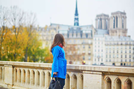 Beautiful young tourist in Paris, walking near Notre-Dame cathedralの写真素材