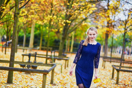 Beautiful young woman in blue dress in the Luxembourg garden of Paris on a fall dayの写真素材