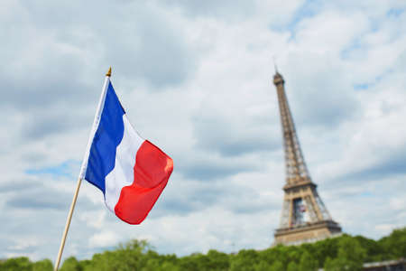 French national flag (tricolour) in Paris with the Eiffel tower in the background. July the 14th, French national holiday conceptの写真素材