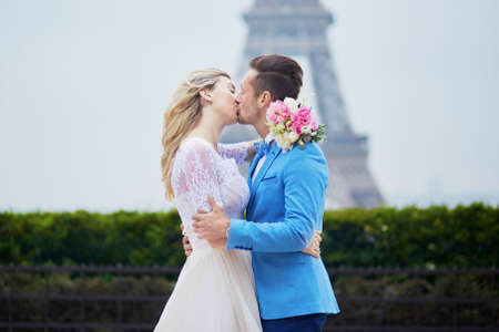 Just married couple near the Eiffel tower on their wedding day. Bride and groom in Paris, Franceの写真素材
