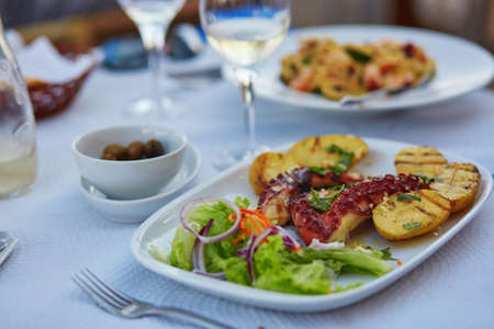 Grilled octopus with baked potatoes in Portuguese seafood restaurantの写真素材
