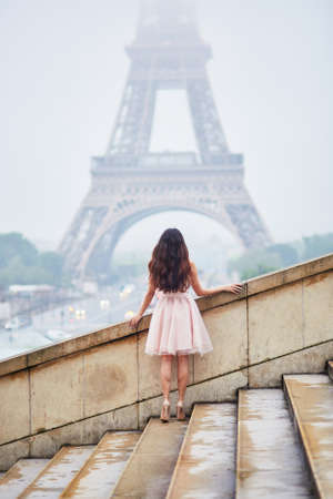 Happy young woman in pink tutu dress near the Eiffel tower in Paris, back viewの写真素材