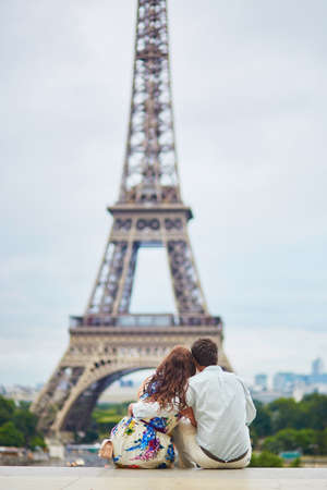 Romantic loving couple having a date near the Eiffel tower. Tourists on vacation or during their honeymoon in Paris, Franceの写真素材