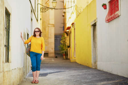 Beautiful young woman on a typical street of Lisbon, Portugalの写真素材