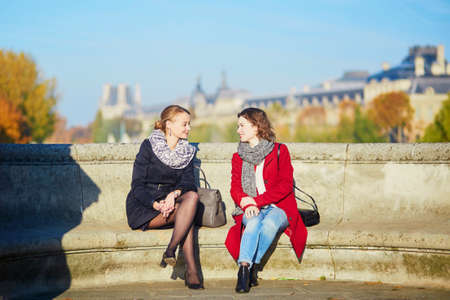 Two young girls walking together in Paris on a sunny fall day. Tourism or friendship conceptの写真素材