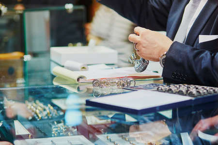Jeweller with many wedding ring samples for size identificationの写真素材
