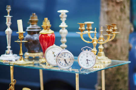 Old alarm clocks and candle holders on flea market in Paris, Franceの写真素材