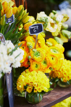 Outdoor flower market with mimosa, ranunculuses and narcissi in Paris, Franceの写真素材