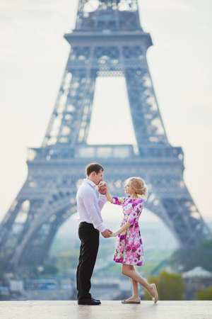 Beautiful romantic couple in front of the Eiffel tower in Paris, France
