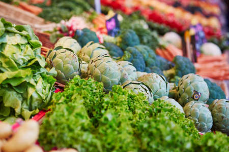 Large heap of fresh ripe organic artichokes on farmer market in Paris, France
