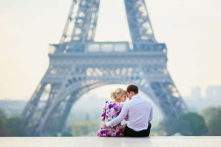 Romantic loving couple sitting on the ground near the Eiffel tower in Paris, Franceの写真素材