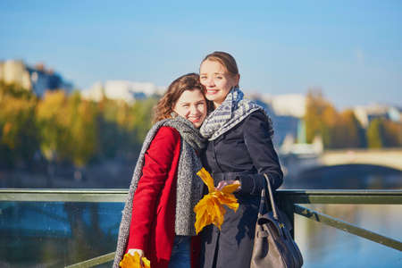 Two young girls walking together in Paris on a sunny fall day. Tourism or friendship conceptの写真素材