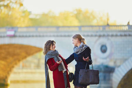Two young girls walking together in Paris on a sunny fall day. Tourism or friendship conceptの写真素材
