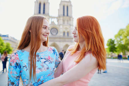 Two young girls together in Paris near Notre-Dame cathedral. Tourism or friendship conceptの写真素材
