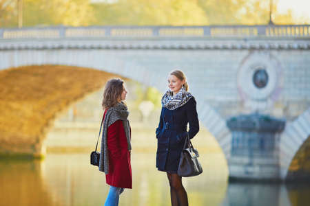 Two young girls walking together in Paris on a sunny fall day. Tourism or friendship conceptの写真素材