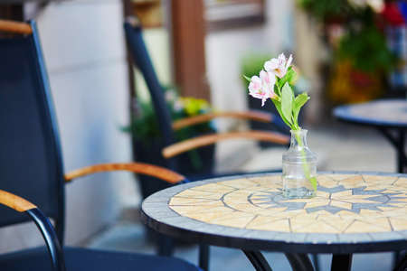 Table of an outdoor cafe in Vilnius, Lithuania, decorated with flower on a summer dayの写真素材