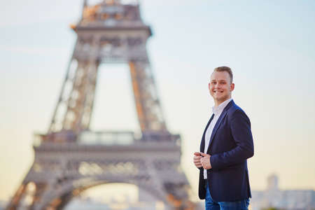 Handsome young man near the Eiffel tower in Parisの写真素材