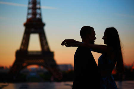 Silhouettes of romantic couple near the Eiffel tower at sunrise, Paris, Franceの写真素材