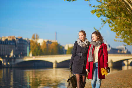 Two young girls walking together in Paris on a sunny fall day. Tourism or friendship conceptの写真素材