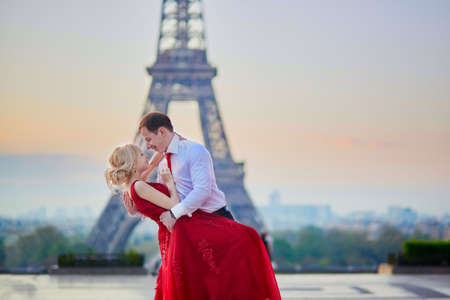 Beautiful romantic couple kissing in front of the Eiffel tower in Paris, Franceの写真素材