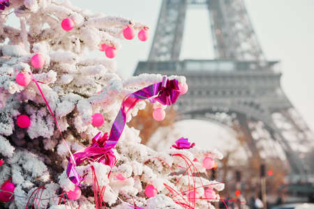 Decorated Christmas tree covered with snow near the Eiffel tower in Paris, Franceの写真素材