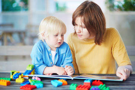 Young mother reading book to her son. Quality family time with kidsの写真素材