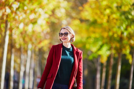 Beautiful young woman walking in park on a fall dayの写真素材
