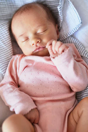 Newborn baby girl sleeping peacefully in the cribの写真素材
