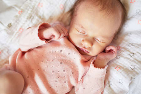 Newborn baby girl sleeping in her crib. Infant having day napの写真素材