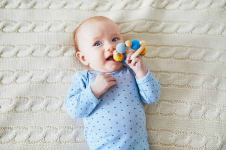 Newborn baby girl playing with colorful teething toy. Development games for infantsの写真素材