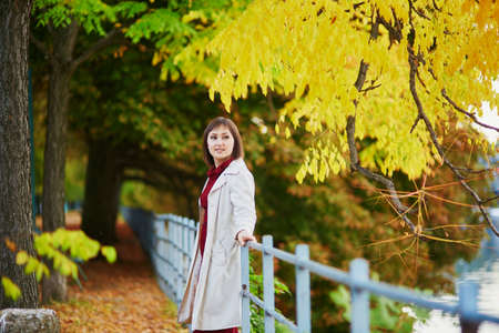 Beautiful young woman in Paris walking in park on a bright fall day. Tourism and vacation in France...