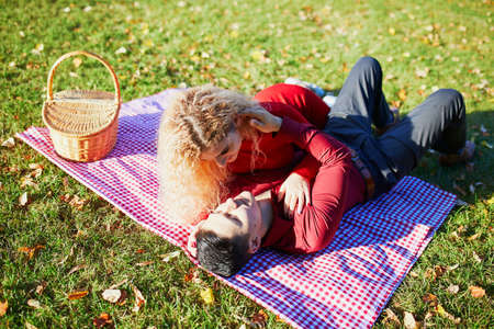 Romantic couple in love having picnic on the grass on autumn day