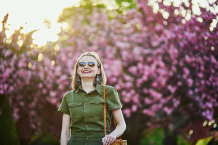 Beautiful French woman walking in Paris on a spring day at cherry blossom seasonの写真素材