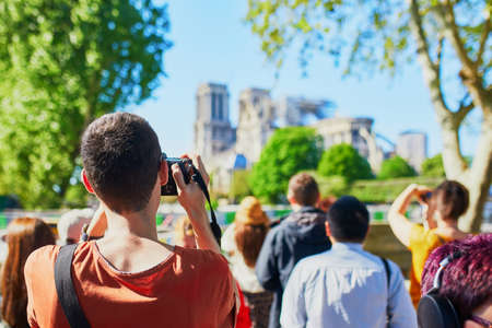 People taking photos of Notre Dame cathedral without roof and spire destroyed by fire in Paris, Franceの写真素材