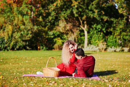Romantic couple in love having picnic on the grass on autumn dayの写真素材