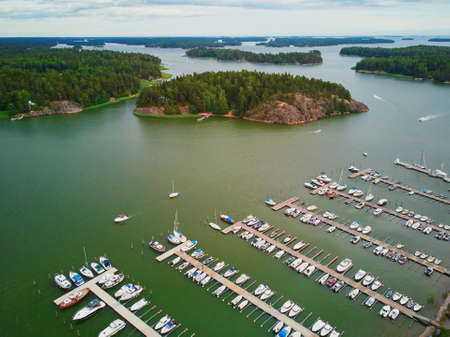 Scenic aerial view of colorful boats near wooden berth in the countryside of Finland