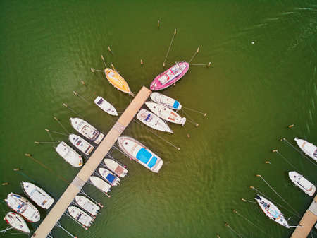 Scenic top down view of colorful boats near wooden berth in the countryside of Finland
