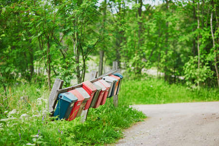 Row of colorful postboxes in the Finnish countryside